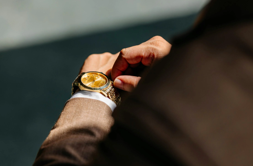 a man wearing a gold wristwatch