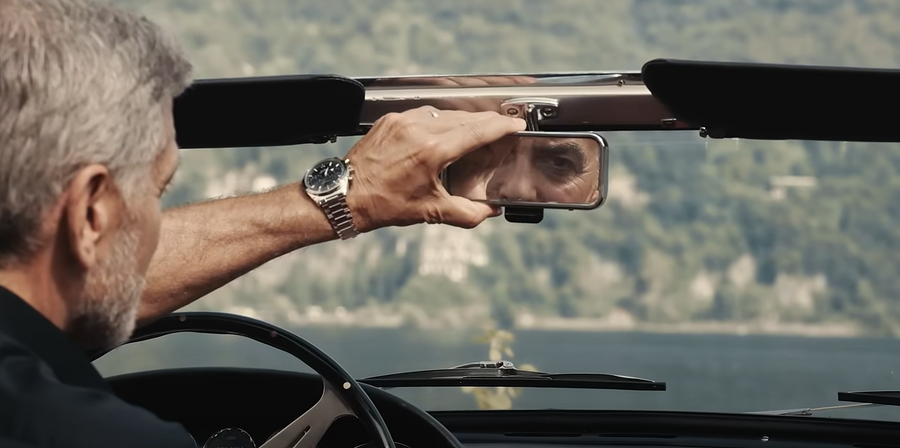George Clooney riding a car wearing the Omega Speedmaster
